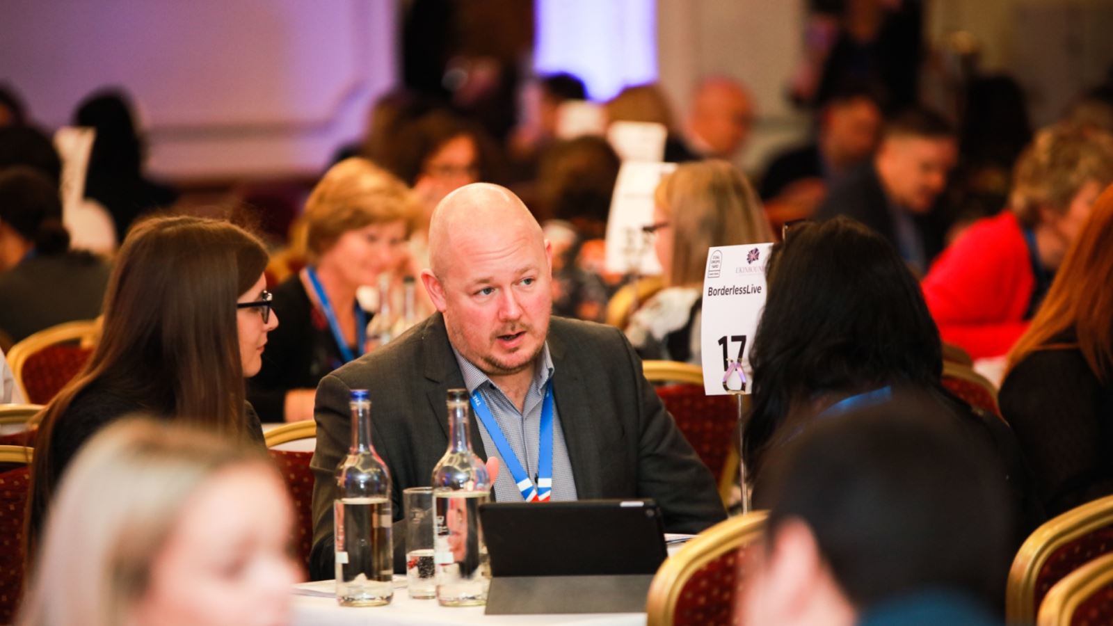 People in a busy room meeting and talking about travel trade opportunities